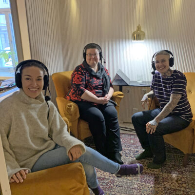 Nata Salmela, Jasmin Hamid ja Tiina Laine istuvat nojatuoleissa kuulokkeet päällä.