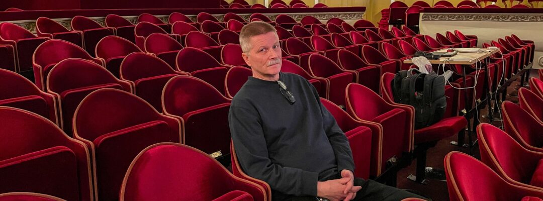 Tom Kumlin sitter på en av teaterns röda bänkar.