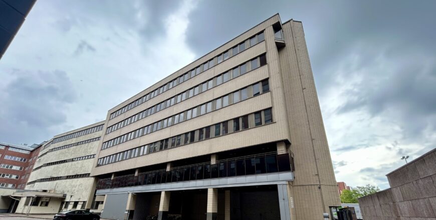 Sörnäisten Rantatien kiinteistö kuvattuna rakennuksen takapuolelta. Takapihalla on parkkipaikka.