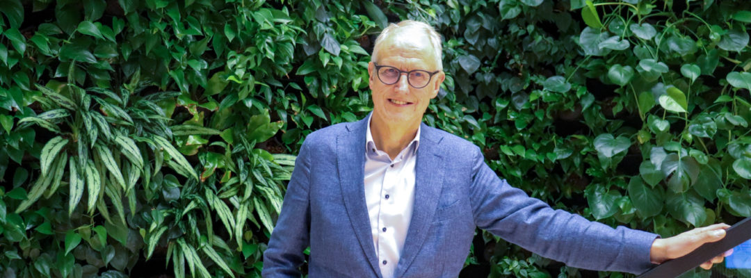 Karlsson seisoo viherseinän edessä toinen käsi kaiteella.