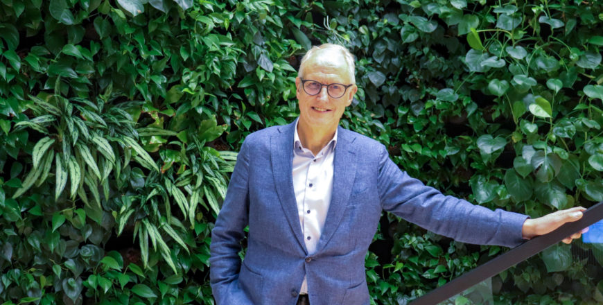 Karlsson seisoo viherseinän edessä toinen käsi kaiteella.
