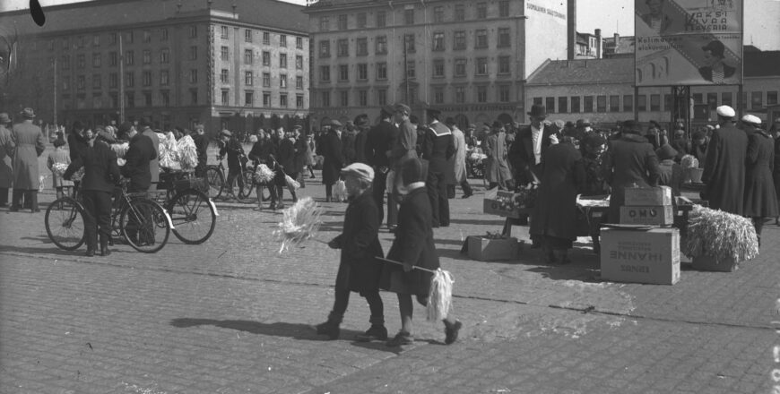 Vanha mustavalkoinen kuva Turun Kauppatorista. Taustalla näkyy Maamiesten kauppatalo. Rakennusten etupuolella on ohikulkijoita.