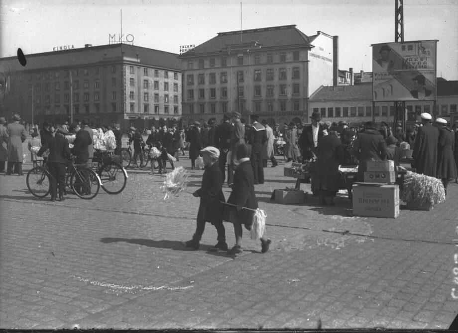 Vanha mustavalkoinen kuva Turun Kauppatorista. Taustalla näkyy Maamiesten kauppatalo. Rakennusten etupuolella on ohikulkijoita.