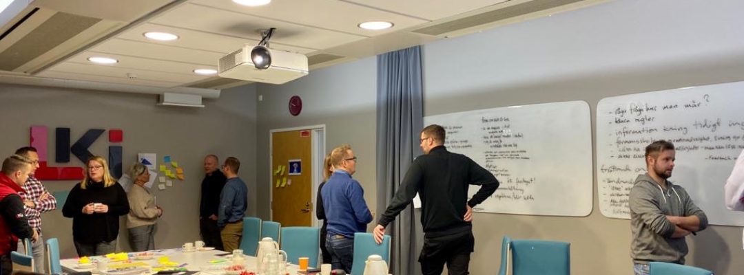 Henkilöitä työskentelee pienryhmissä kokoustilassa.