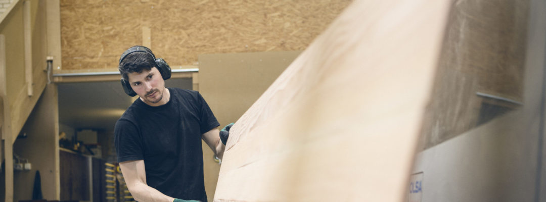 An emplyee is holding a plywood.