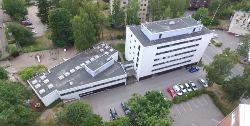 Ilmakuva Asunto Oy Helsingin Meripuistotien kerrostalosta. Etualalla parkkipaikka, ja takana muita kerrostaloja.