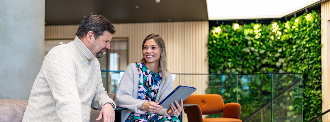 Two employees are using an iPad together at the office in Turku.